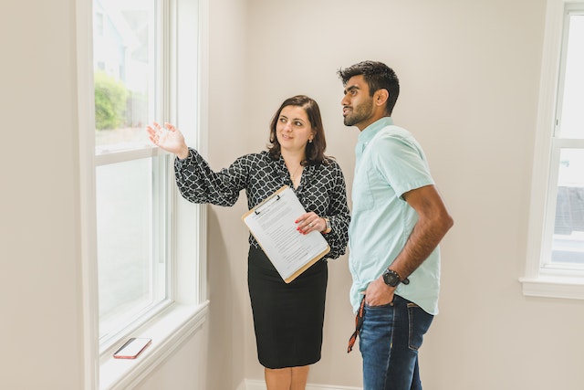 realtor showing a client a house with beige walls